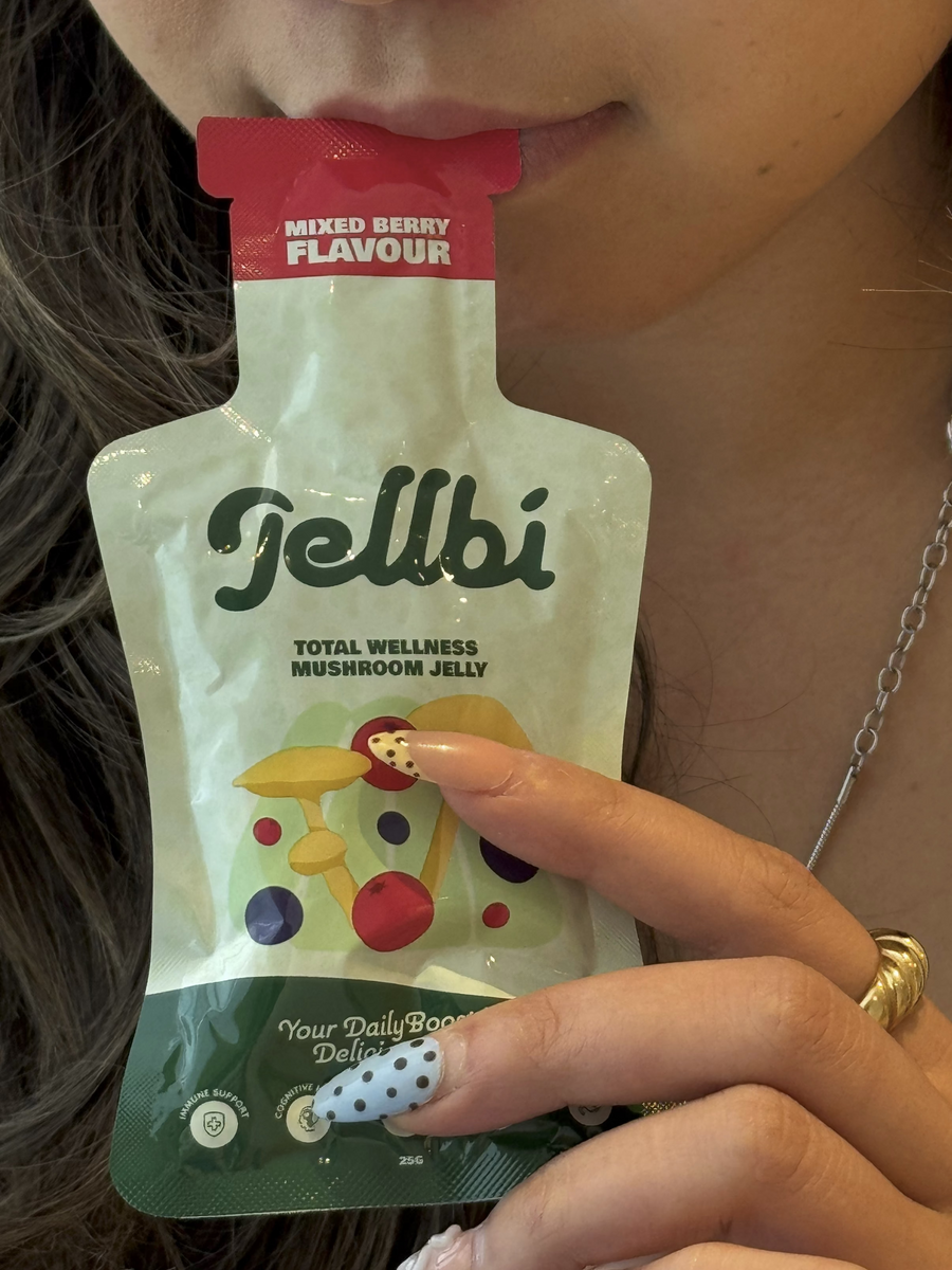 Person holding a Jelbi mushroom jelly packet with a close-up of the packaging.