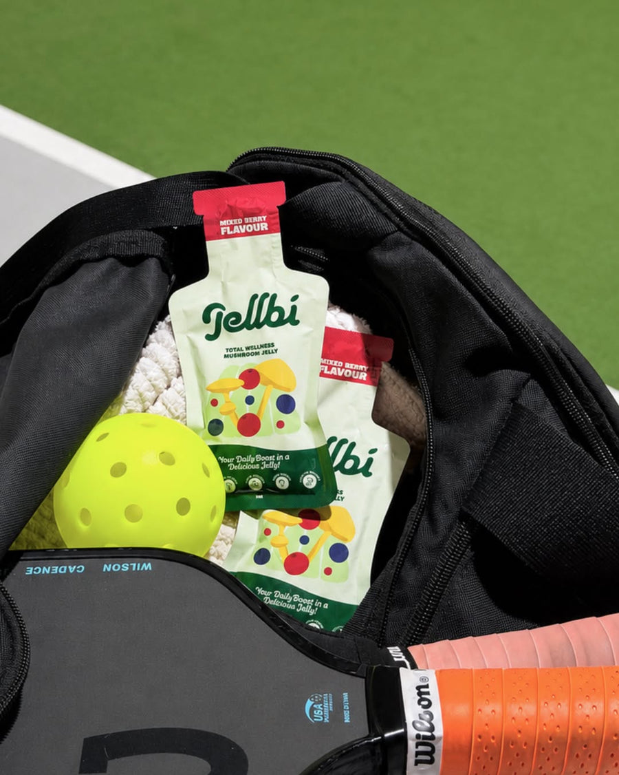 Jellbi sachets packed in a sports bag with a pickleball paddle and ball