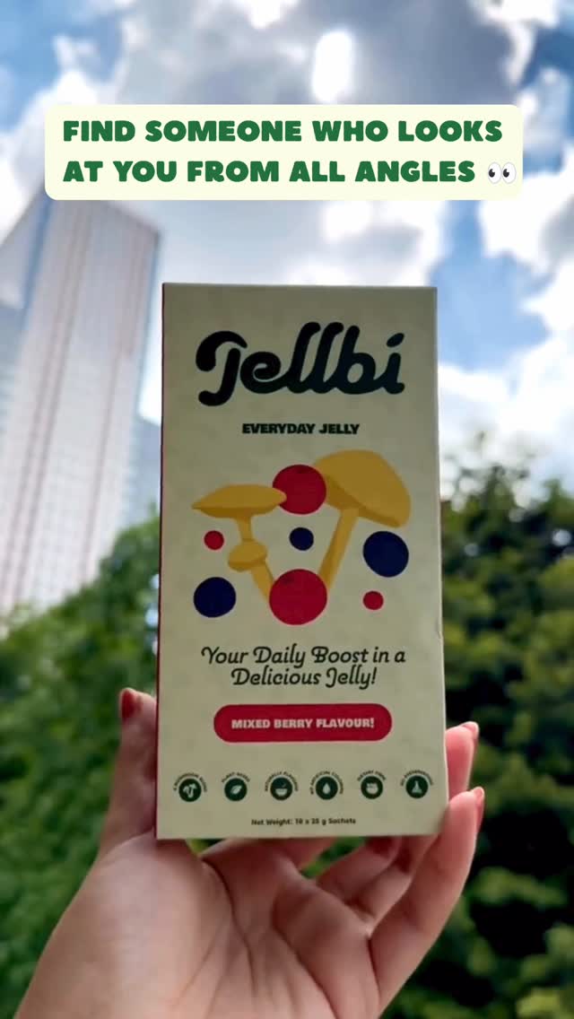 Hand holding a Jellbi Everyday Jelly box against the sky